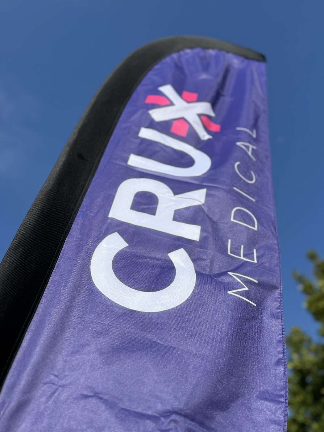 purple ripstock nylon beach flag with the Crux Medical logo