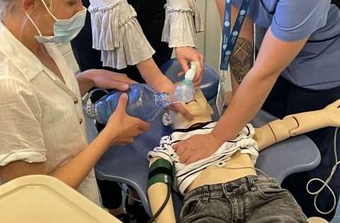 dental team practicing bls on a manequin in a dental surgery